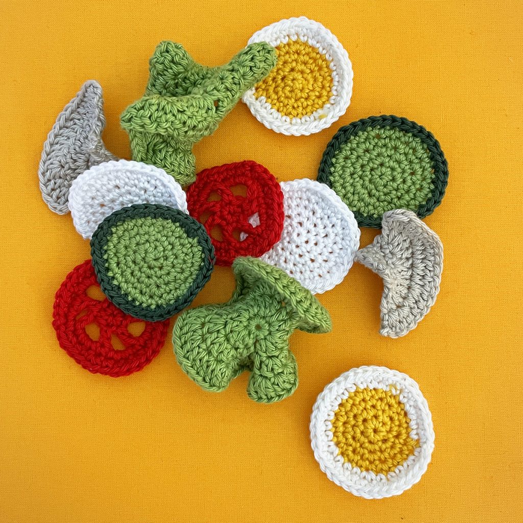 crochet salad consisting of different vegies like lettuce, tomatoes and also egg